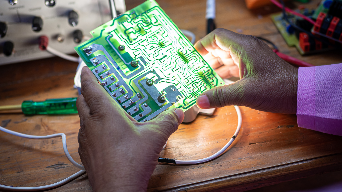 A woman solar engineer learns to build a circuit board during training with Barefoot College International